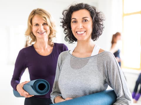 Zwei ältere Frauen mit Sportmatten