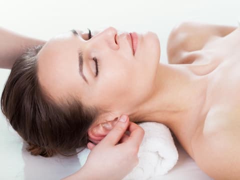 Frau bekommt Ohrmassage