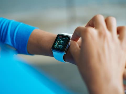 Frau überprüft Display ihrer Fitnessuhr
