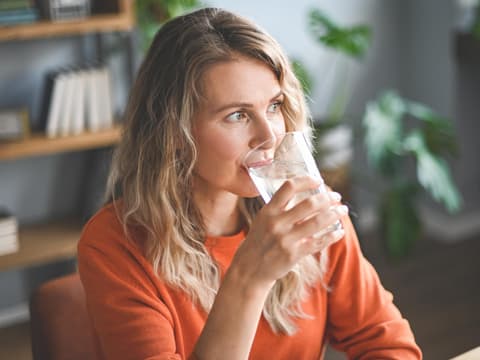 Frau trinkt ein Glas Wasser