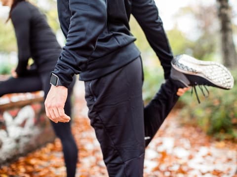 Zwei Jogger dehnen sich