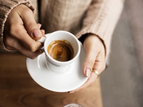 Frau hält Espressotasse in der Hand