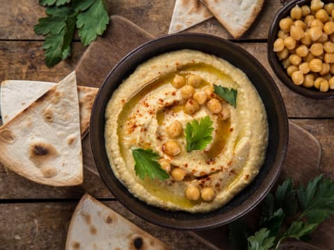 Schüssel mit Hummus und Kichererbsen