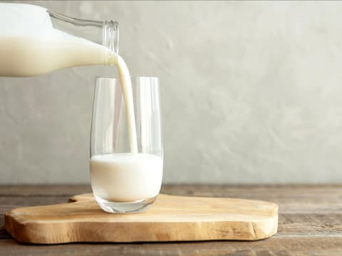 Glas Milch wird eingeschenkt