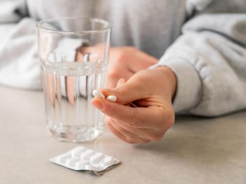 Frau hält zwei Tabletten in den Händen 