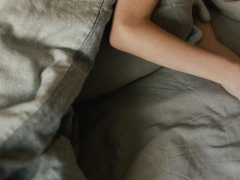 Juckreiz an den Händen, während die Person im Bett liegt
