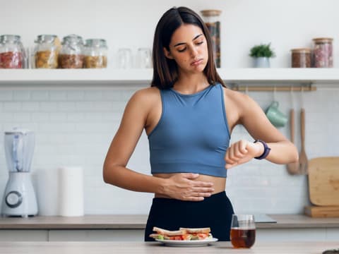 Sportliche junge Frau fastet und hat Hunger