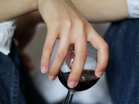 Eine Frau hält lässig ein Glas Wein in der Hand