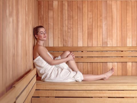 Eine Frau sitzt in der Sauna