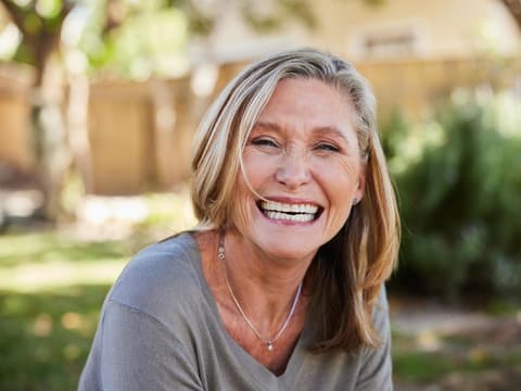 Eine Frau im besten Alter strahlt mir einem breiten Lachen in die Kamera. Sie sieht gesund und glücklich aus. 