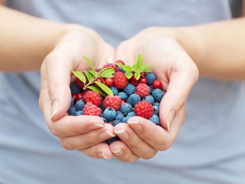 Frau hält Beeren in den Händen