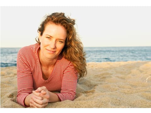 Frau liegt am Strand