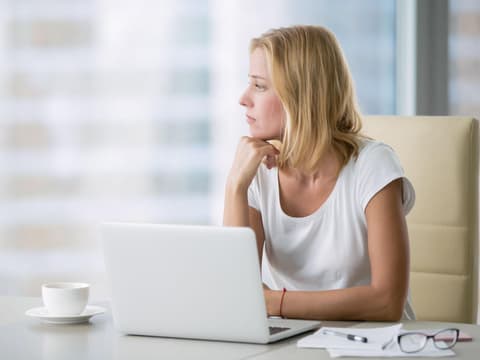 Frau am Laptop nachdenklich unkonzentriert
