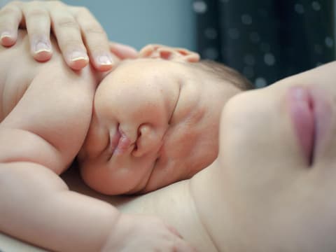 Baby liegt auf Mutter