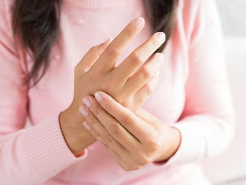 Frau hält sich die Hand