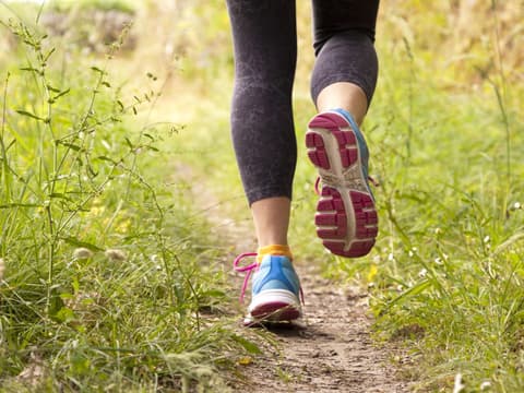 Frau joggt auf Feldweg