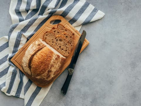 Frisches Brot auf Brett und Handtuch