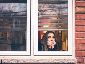 Frau am Fenster Frau guckt aus dem Fenster