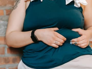 Übergewichtige Frau greift Bauchfett mit den Händen Übergewichtige Frau greift Bauchfett mit den Händen