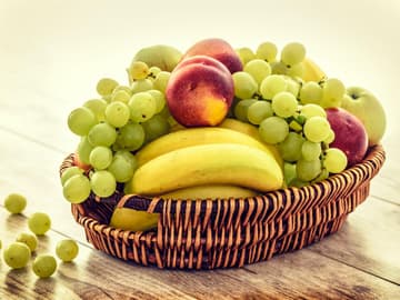 Obstkorb mit Bananen und Weintrauben Obstkorb mit Bananen und Weintrauben