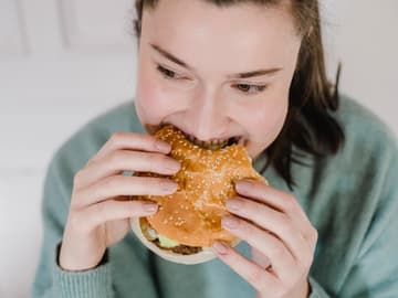 Frau isst Hamburger Frau isst Hamburger