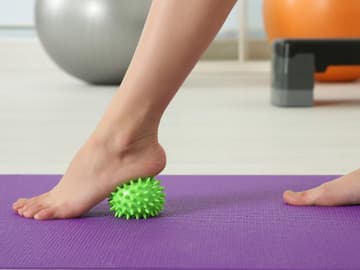 Fuß rollt über stacheligen Massageball Fuß rollt über stacheligen Massageball