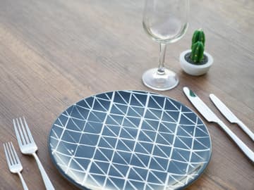 Ein leerer Teller mit Besteck und einem Glas Ein leerer Teller mit Besteck und einem Glas