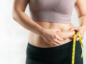 Frau fasst sich an den Bauch Frau fasst sich an den Bauch