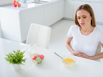 Frau hat Bauchschmerzen beim Essen Frau hat Bauchschmerzen beim Essen