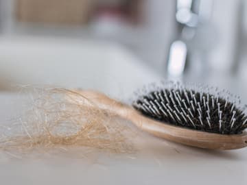 Haarbüschel neben Bürste Haarbüschel neben Bürste