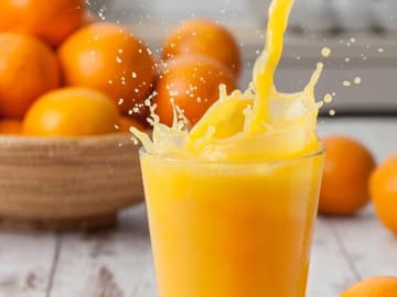 Orangensaft wird in ein Glas gegossen Orangensaft wird in ein Glas gegossen