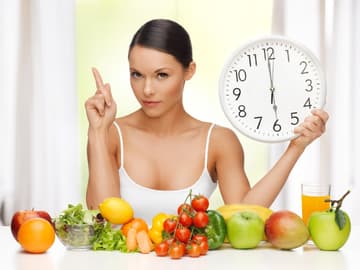 Obst, Gemüse und eine Frau, die eine Uhr in der Hand hält Obst, Gemüse und eine Frau, die eine Uhr in der Hand hält