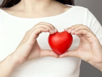 Frau hält ein Herz in der Hand Frau hält ein Herz in der Hand