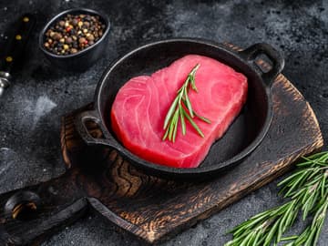 Thunfischsteak frisches Thunfischsteak in Pfanne mit Rosmarinzweig