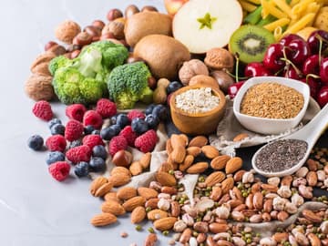 Verschiedene pflanzliche Lebensmittel wie Obst, Gemüse, Nüsse und Samen Verschiedene pflanzliche Lebensmittel wie Obst, Gemüse, Nüsse und Samen