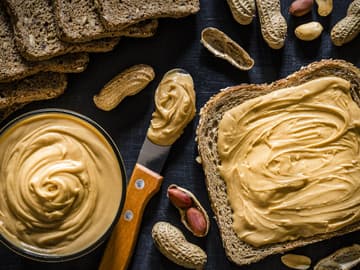 Erdnussbutter ist beliebt als Aufstrich Cremige Ernussbutter auf Vollkorntoastbrot