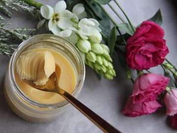 Ghee eignet sich zum Braten Glas Ghee mit Holzlöffel