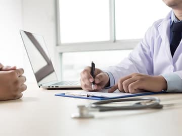 Tipps gegen Haarausfall Arzt Beratung Arzt berät einen Patienten zu Tipps gegen Haarausfall
