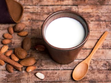 Mandelmilch ist kalorienarm Mandeln und frische Mandelmilch auf Holztisch