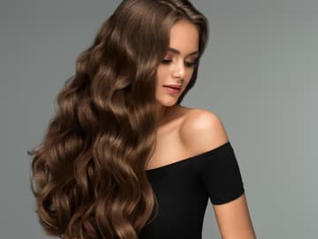Lange, gelockte Haare einer Frau Lange, gelockte Haare einer Frau