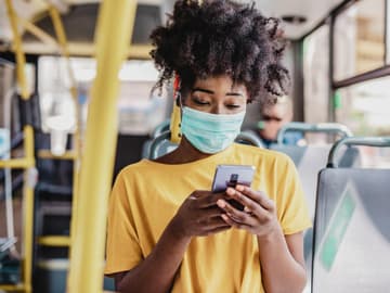 Masketragen schützt auch vor Sommergrippe Frau trägt Maske im Linienbus