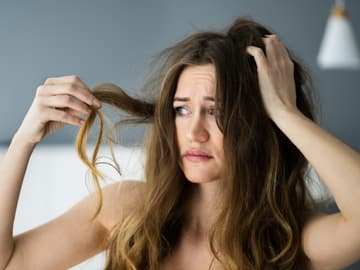 Frau begutachtet Haare Frau begutachtet Haare