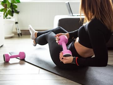 Hantelübungen sind effektiv für den Bauch Frau macht Bauchübung mit Hantel zu Hause