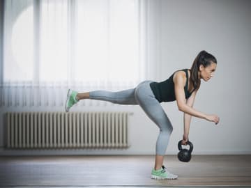 Die einbeinige Übung strafft ungemein Frau macht Single Leg Deadlift mit Kettlebell