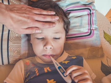 Kind mit Fieberthermometer im Mund Kind mit Fieberthermometer im Mund