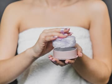 Körperpuder duftet himmlisch Frau trägt Puder mit Quast auf