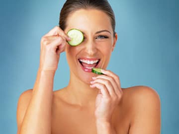 Superfood Gurke Frau mit Gurkenscheiben in der Hand