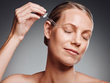 PHA-Peelings sind besonders mild reife Frau trägt Serum mit Pipette auf