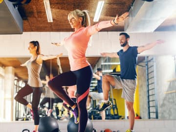 Einbeiniges Stehen trainiert Gleichgewicht Sportgruppe übt einbeiniges Stehen