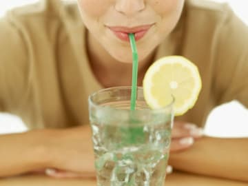Frauen können sich mit Zitronen-Minze-Wasser bei Hitze abkühlen Frauen können sich mit Zitronen-Minze-Wasser bei Hitze abkühlen